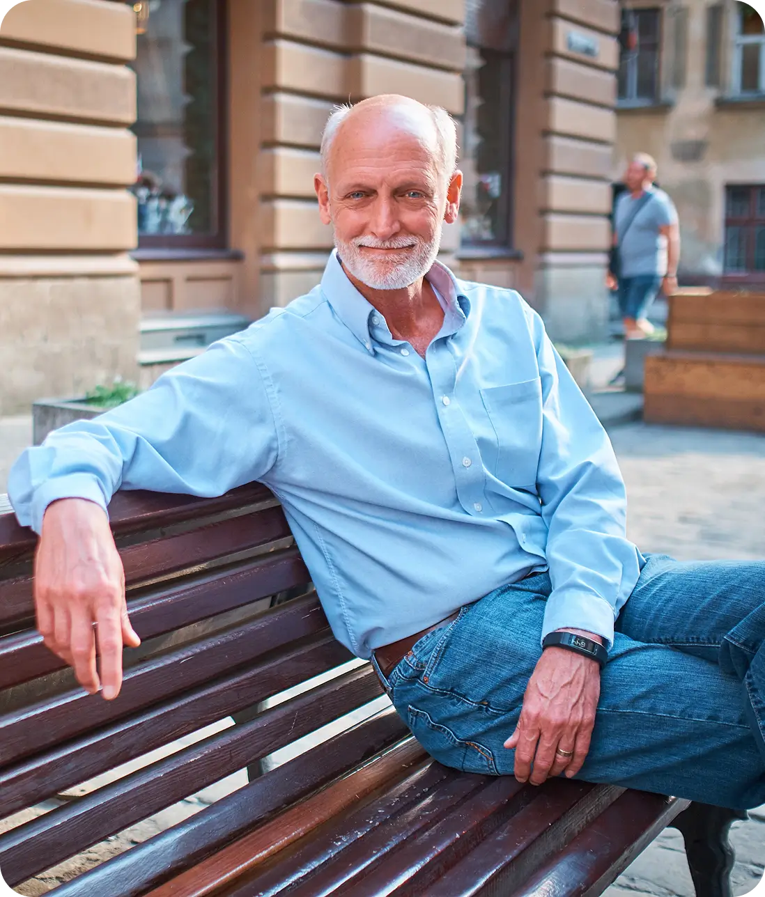 Michael Pratt sitting on a bench outdoors, smiling